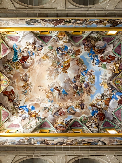 Ceiling fresco in San Lorenzo de El Escorial, depicting vibrant historical and religious scenes.