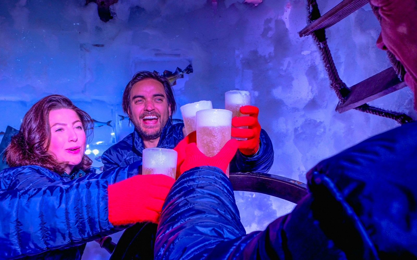 Guests enjoying drinks at Icebar Amsterdam with ice walls and vibrant lighting.