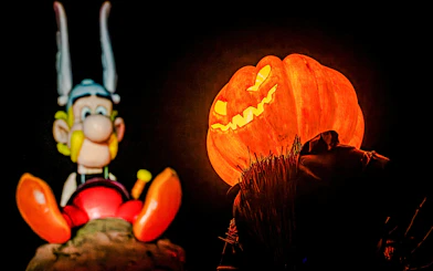 Asterix statue and glowing jack-o'-lantern at Parc Asterix Halloween event in Paris, France.