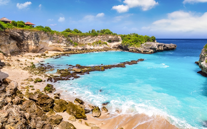 Blue Lagoon at Nusa Ceningan, Bali, with turquoise waters and rocky cliffs.