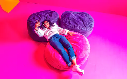 Guest relaxing on colorful bean bags at Dopamine Land.