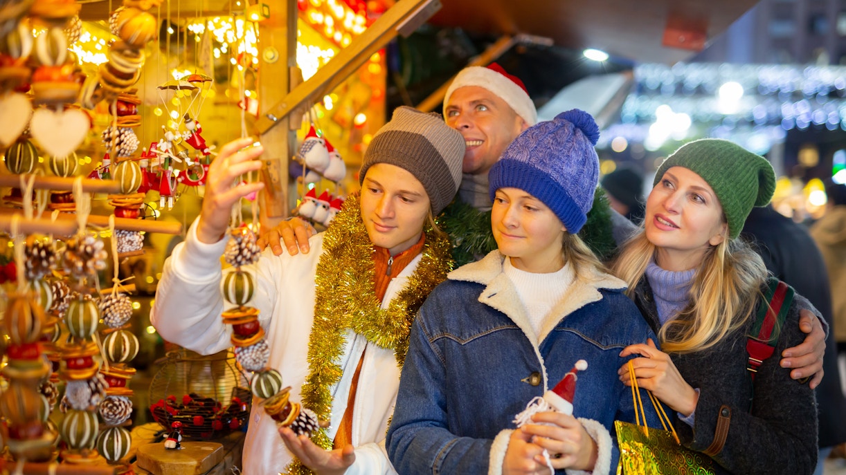 Family exploring Christmas market in Prague, December.