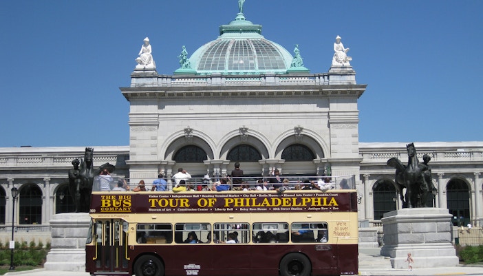 Philadelphia tour bus in front of Memorial Hall on a sunny day.