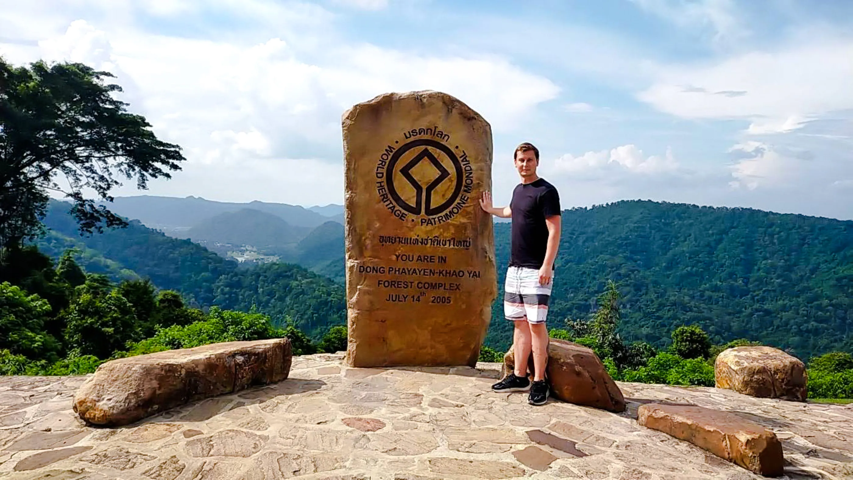 Man standing by Dong Phayayen-Khao Yai Forest Complex sign, Khao Yai National Park.