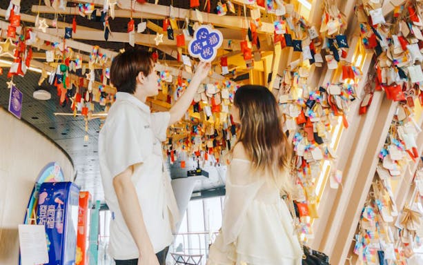 Visitors viewing colorful hanging wishes inside Shanghai Tower.