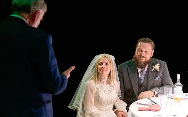 Bride and groom seated at a table during a wedding scene from "Till The Stars Come Down.