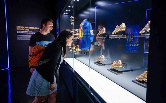 Visitors viewing Messi memorabilia at Spotify Camp Nou Barça Museum.