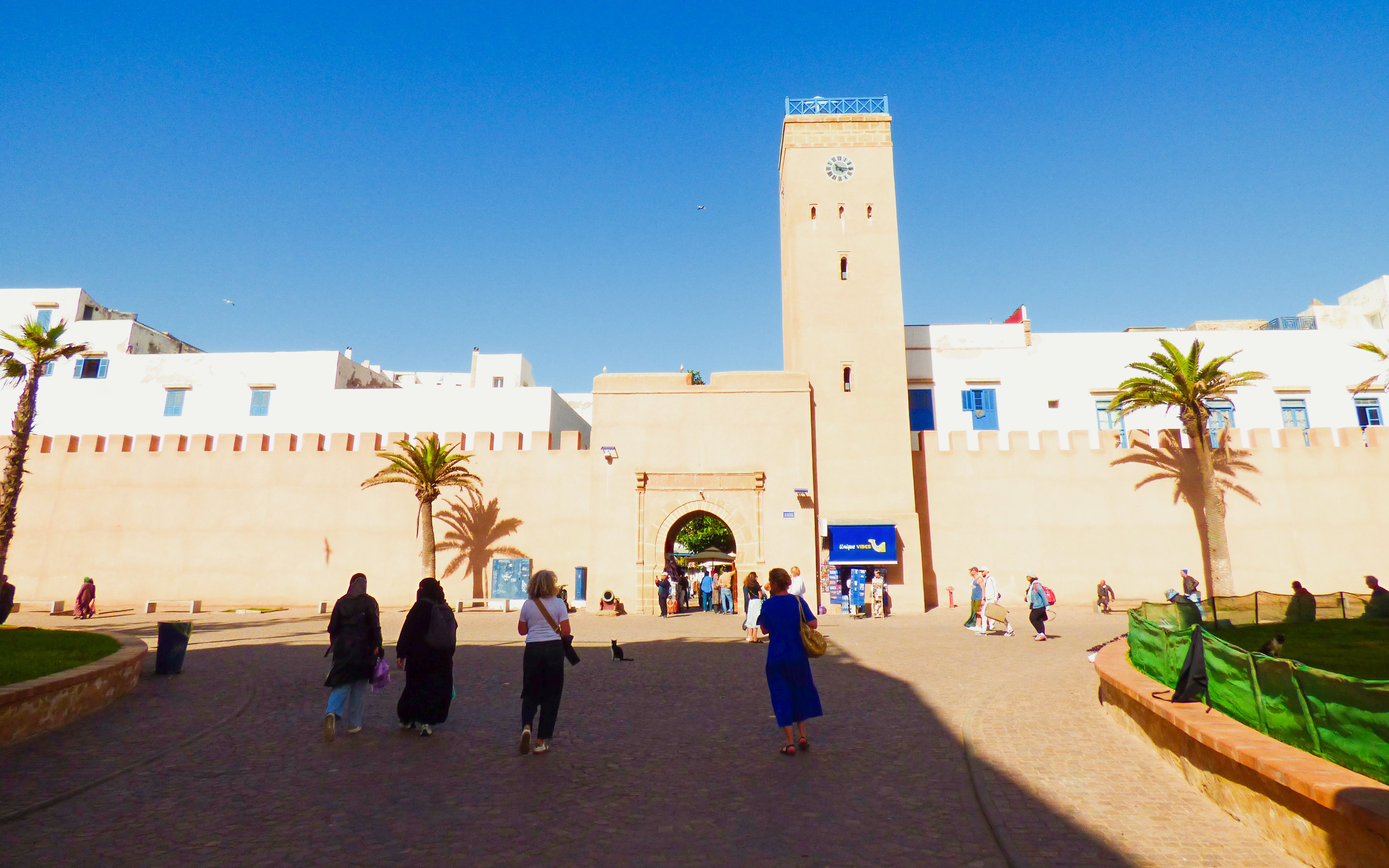 Entrance to the medina in Essaouira, Morocco, with people walking towards the gate.
