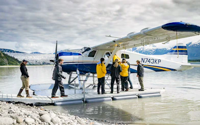 Seaplane on lake with people boarding, glacier and mountains in background, Norris Adventure tour.