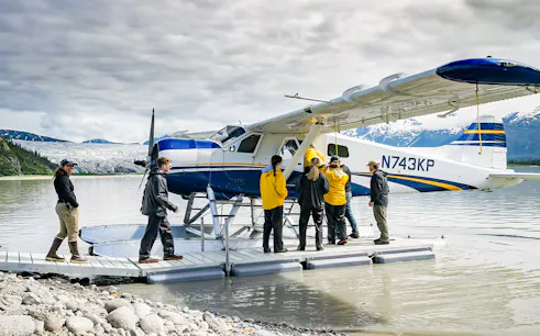 Seaplane on lake with people boarding, glacier and mountains in background, Norris Adventure tour.