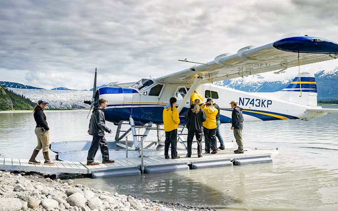 Seaplane on lake with people boarding, glacier and mountains in background, Norris Adventure tour.