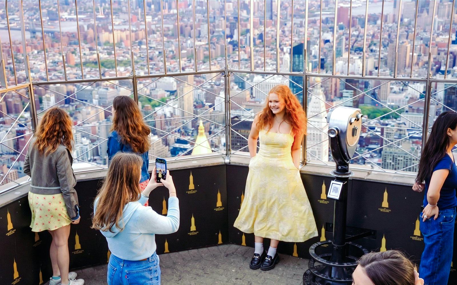 Visitors enjoying the view from the Empire State Building observation deck in New York City.