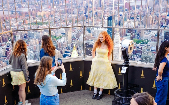 Visitors enjoying the view from the Empire State Building observation deck in New York City.