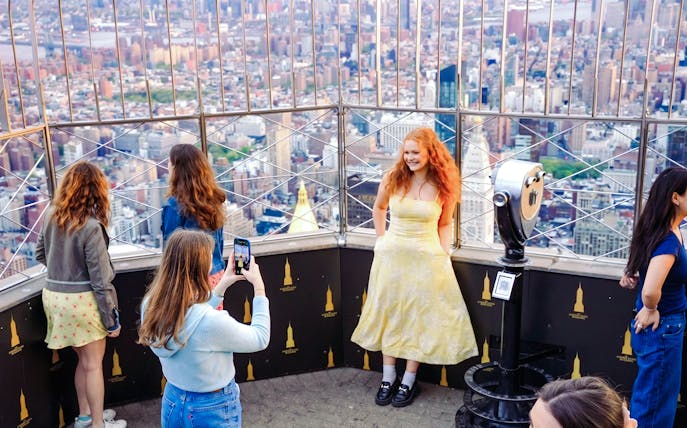 Visitors enjoying the view from the Empire State Building observation deck in New York City.