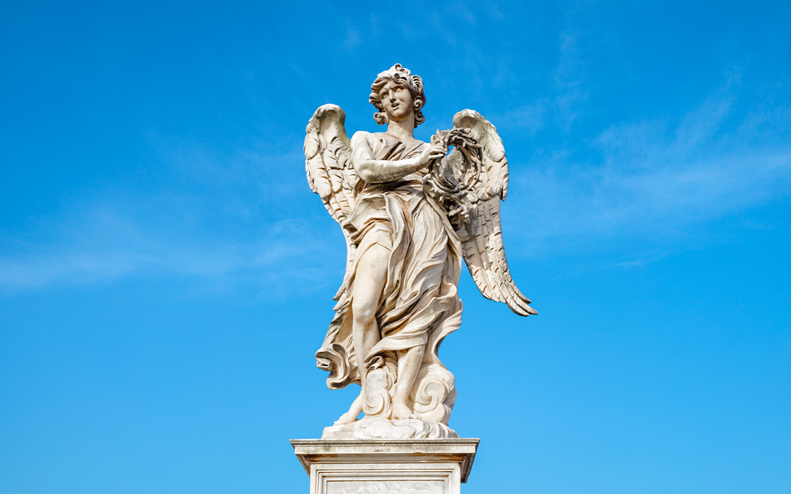Angel statue holding crown of thorns on Ponte Sant'Angelo bridge, Rome, Italy.