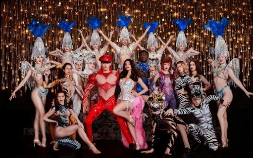 Performers in elaborate costumes on stage during Paris Bastille Day Dinner Cruise.