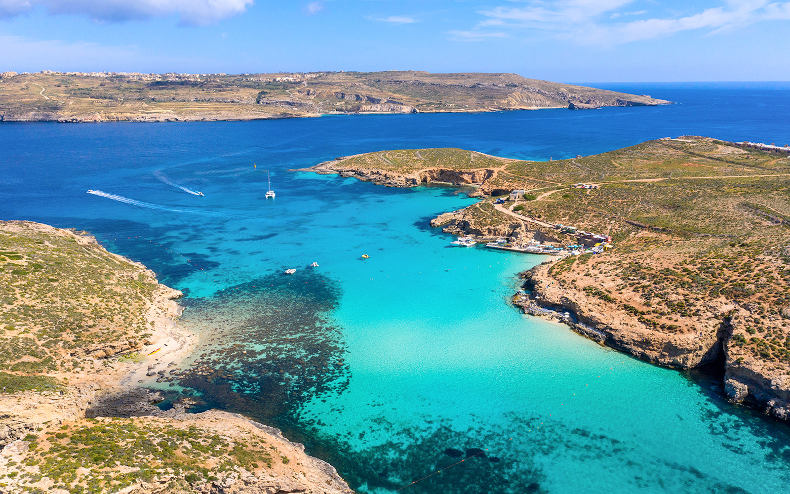 Aerial view of Blue Lagoon's turquoise waters and rocky coastline in Malta.