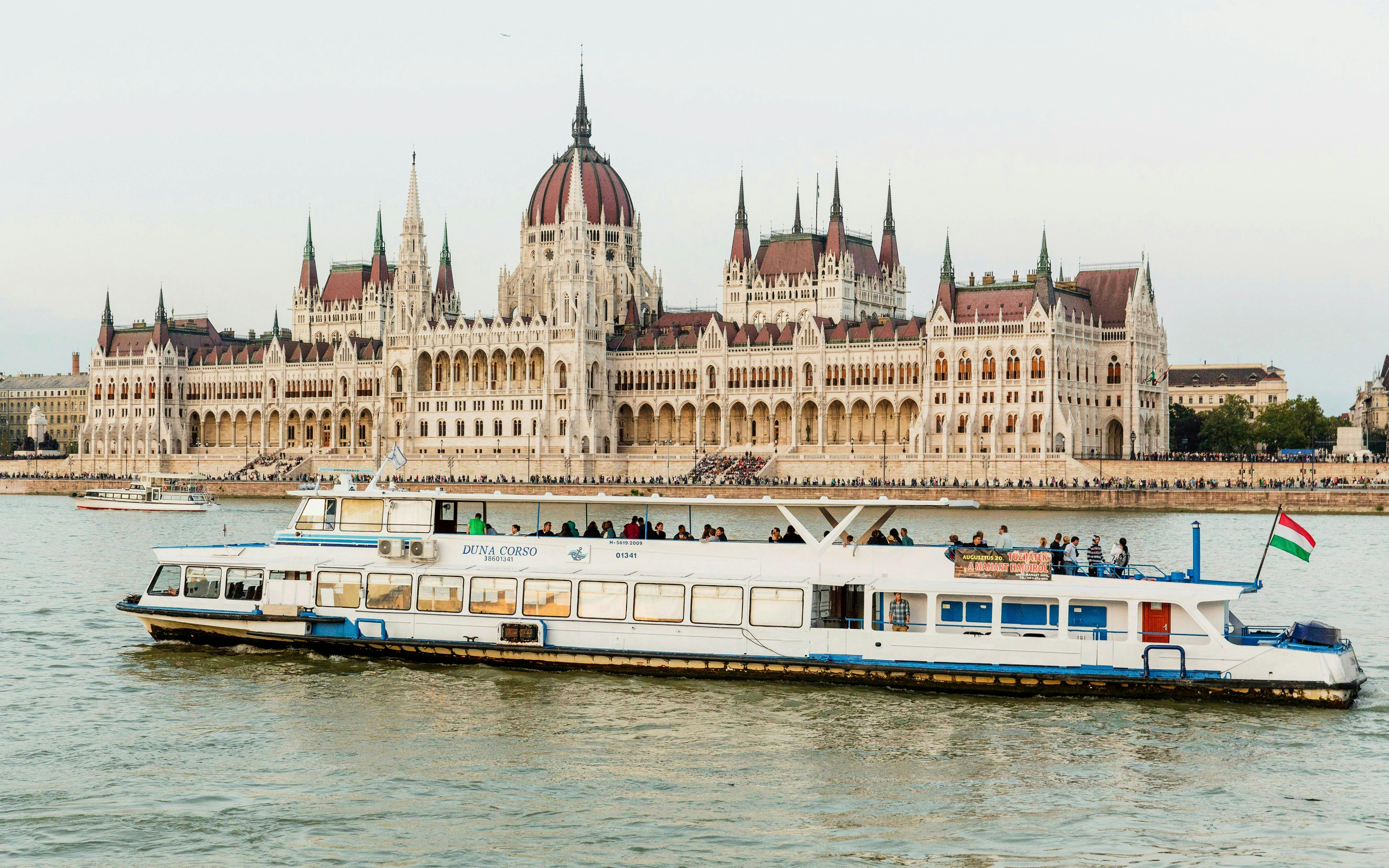Tourist boat cruising past the Hungarian Parliament Building on Budapest Daytime Hop-on Hop-off Cruise.