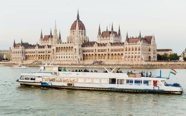 Tourist boat cruising past the Hungarian Parliament Building on Budapest Daytime Hop-on Hop-off Cruise.