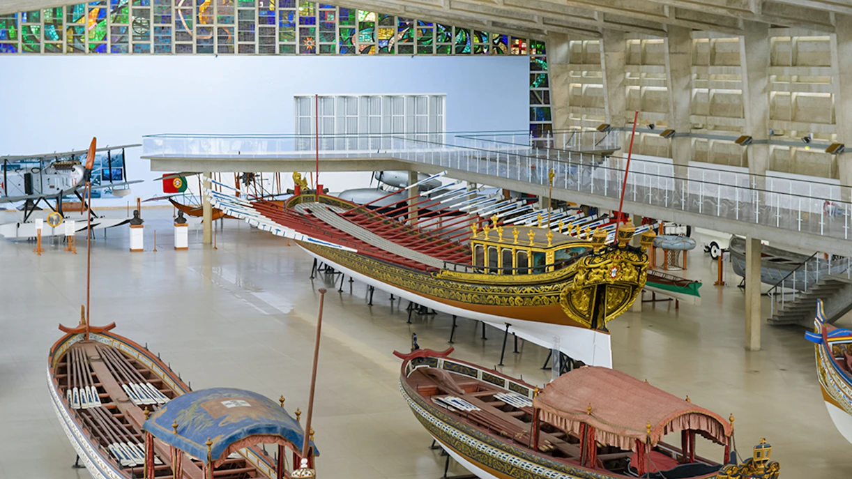 Historic boats displayed at the Maritime Museum in Lisbon, featuring ornate designs and vibrant colors.