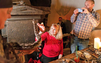 Guests interacting with a snake during a medieval dinner show at Dětenice Brewery near Prague.