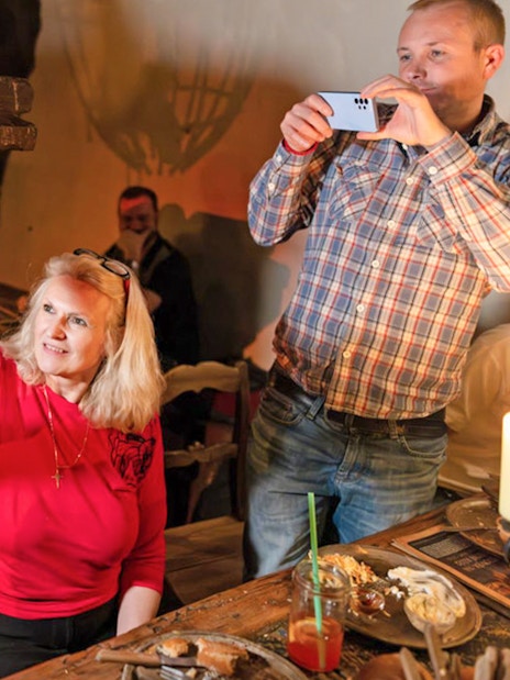 Guests interacting with a snake during a medieval dinner show at Dětenice Brewery near Prague.