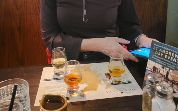 Whisky tasting setup with three glasses on a map in Glasgow.