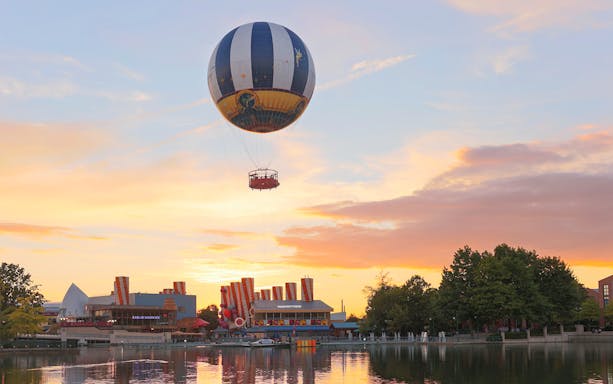 Ballon Panoramagique floating over a lake at sunset in Disneyland Paris.