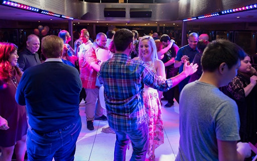 People dancing on a New York party cruise during happy hour.
