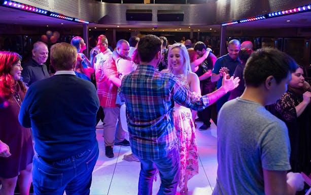 People dancing on a New York party cruise during happy hour.