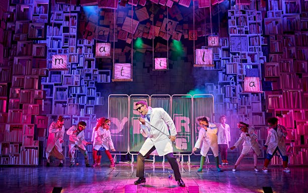 Performers in lab coats on stage during Matilda The Musical, West End.