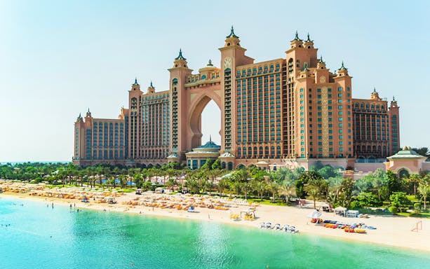 Atlantis Dubai resort with beach and palm trees in the foreground.