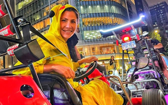 Go-karting tour participant in costume driving through Shibuya, Tokyo at night.
