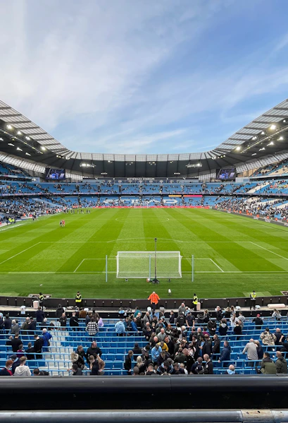 Manchester City Stadium with spectators gathering for a tour.