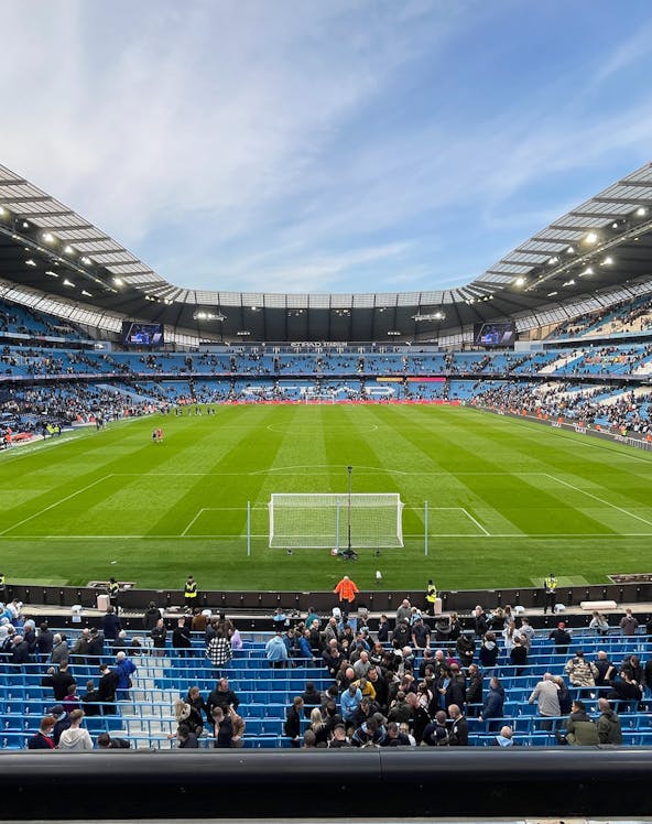 Manchester City Stadium with spectators gathering for a tour.