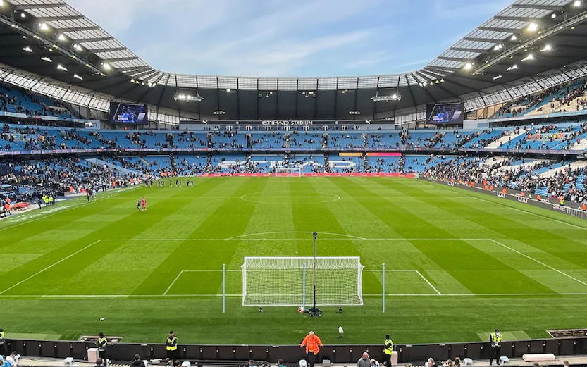 Manchester City Stadium with spectators gathering for a tour.