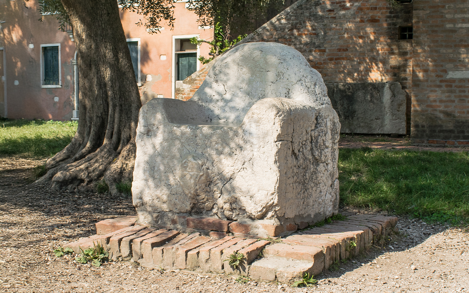 Mysterious stone throne in Venice, known as Attila's Throne, surrounded by historic architecture.
