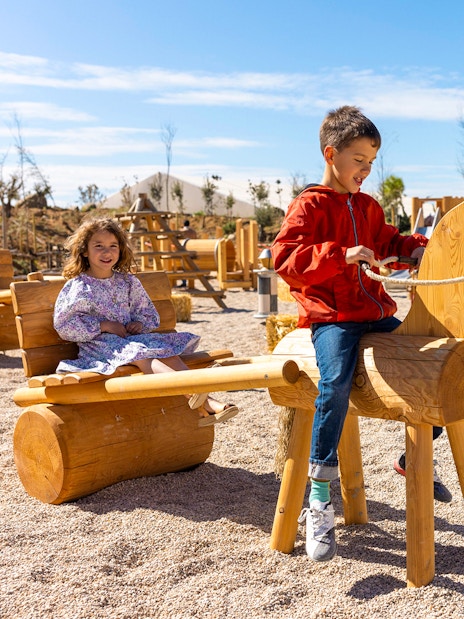 Children playing on wooden structures at Puy du Fou España park.