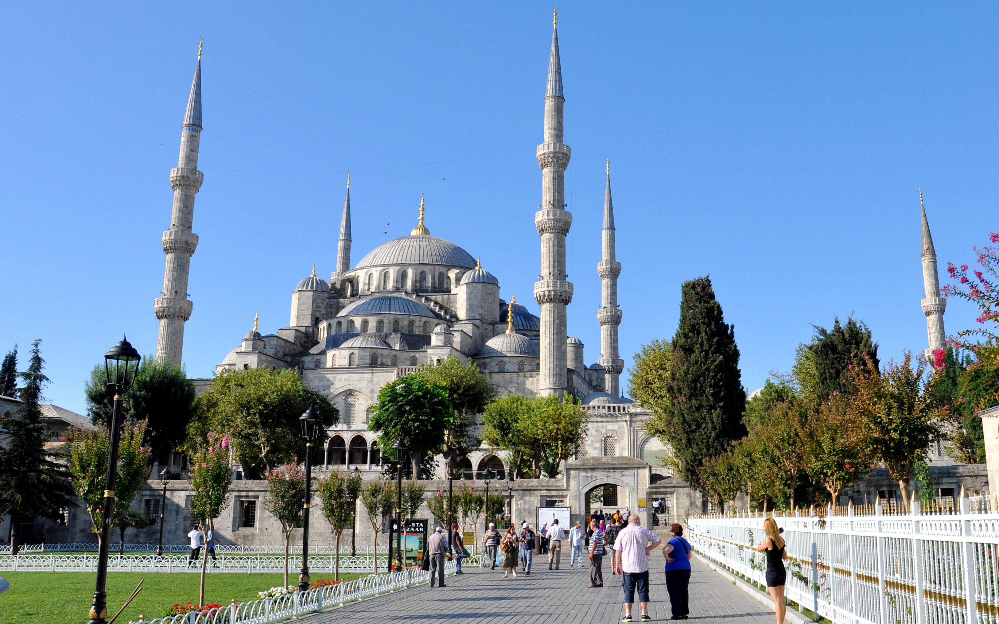 Blue Mosque in Istanbul with visitors walking in the courtyard.