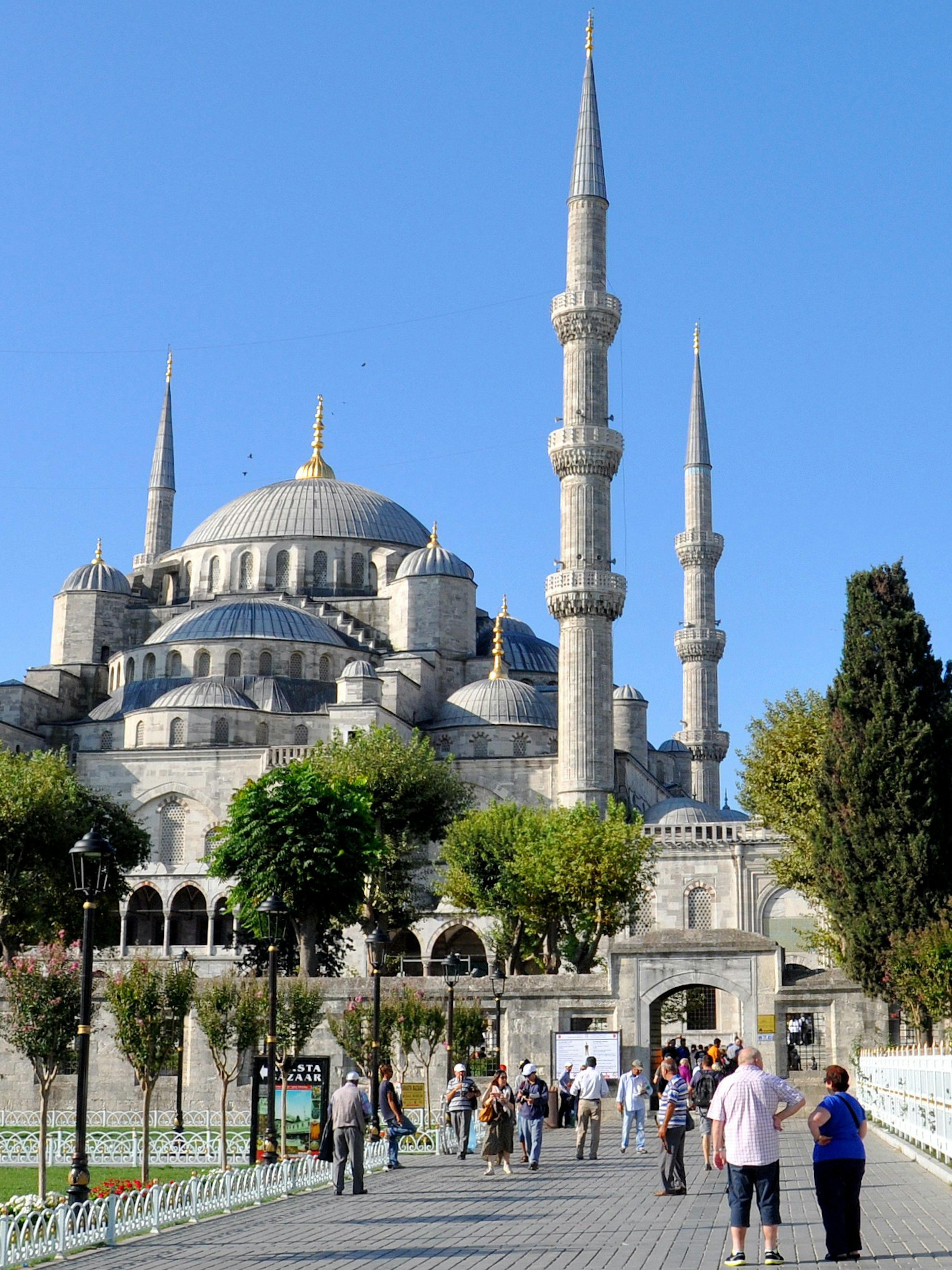 Blue Mosque in Istanbul with visitors walking in the courtyard.
