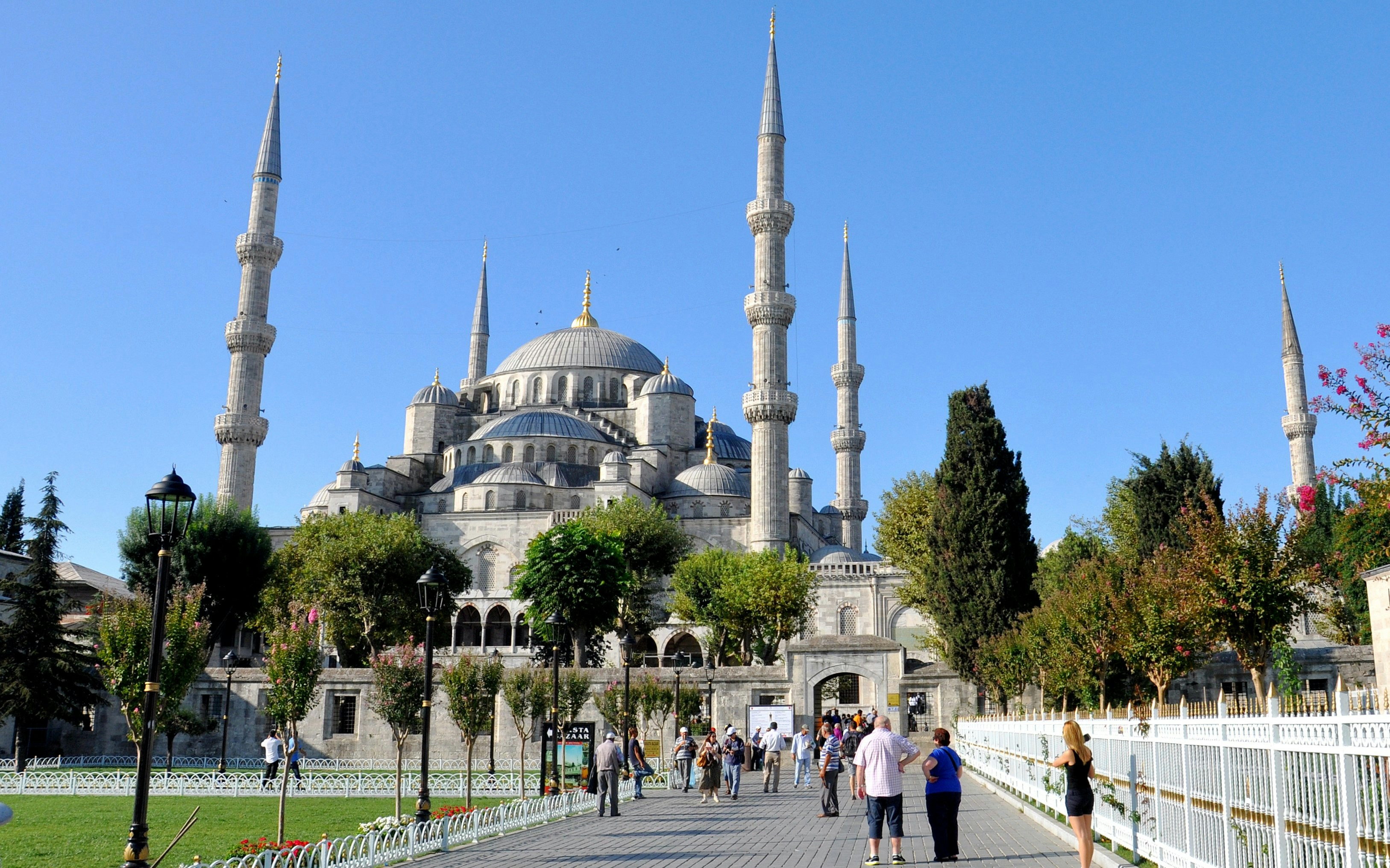 Blue Mosque in Istanbul with visitors walking in the courtyard.