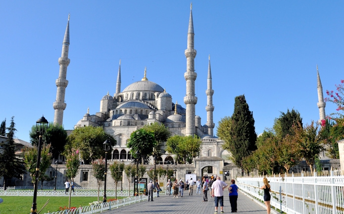 Blue Mosque in Istanbul with visitors walking in the courtyard.