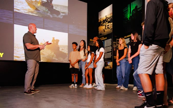 Group tour at The National Navy SEAL Museum, San Diego, with guide explaining exhibits.