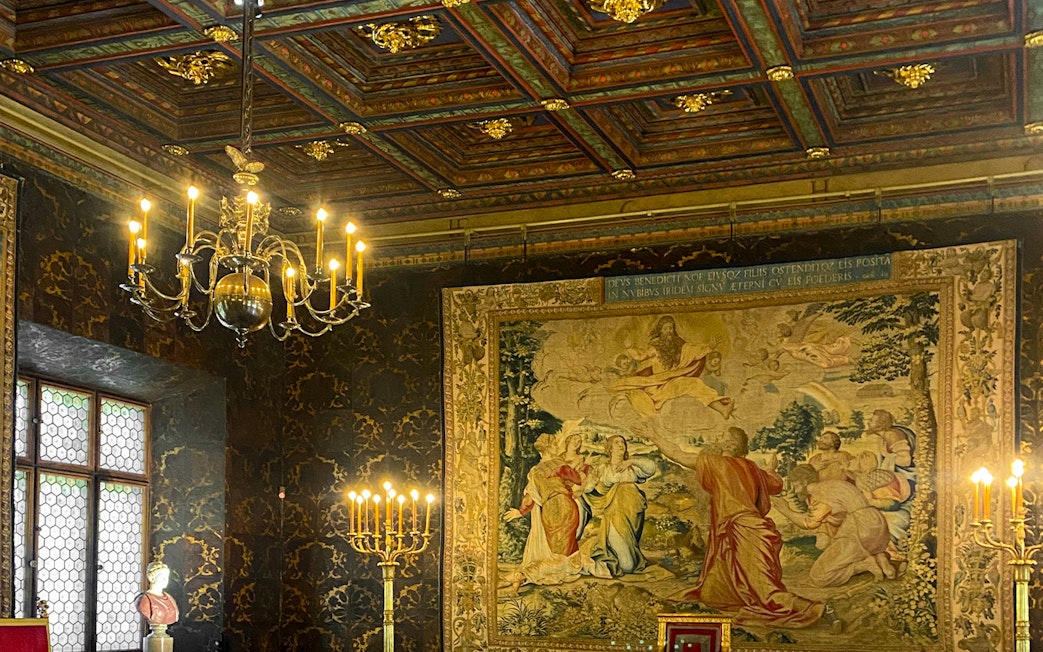 Wawel Castle interior with ornate tapestry and chandelier, Krakow tour.