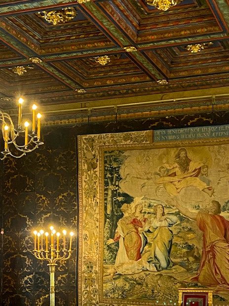 Wawel Castle interior with ornate tapestry and chandelier, Krakow tour.