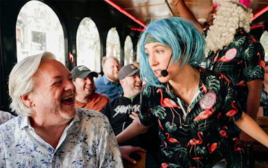 Comedian interacting with laughing passengers on Nashville comedy trolley tour.