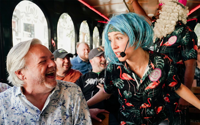 Comedian interacting with laughing passengers on Nashville comedy trolley tour.
