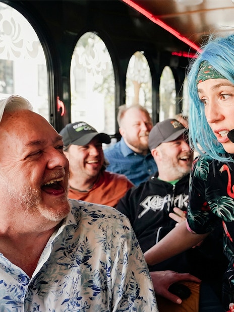 Comedian interacting with laughing passengers on Nashville comedy trolley tour.