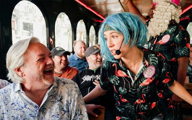 Comedian interacting with laughing passengers on Nashville comedy trolley tour.