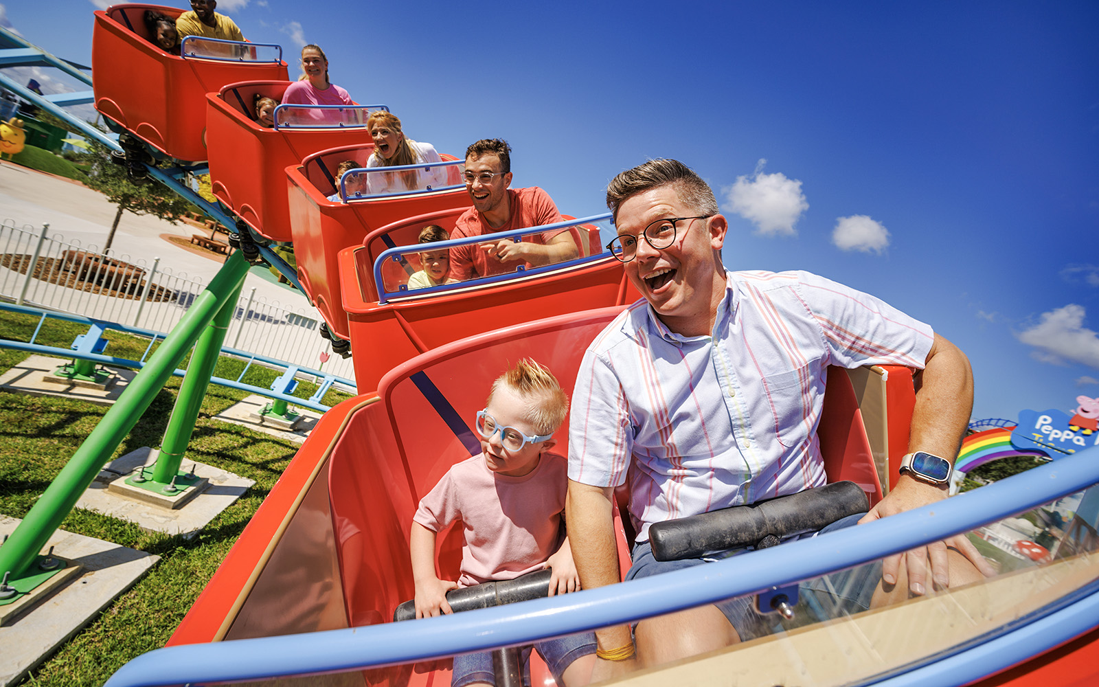 Families enjoying a roller coaster ride at Peppa Pig Theme Park, Florida.